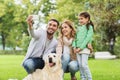 Happy family with dog taking selfie by smartphone