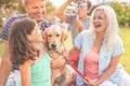 Happy family doing picnic in nature outdoor - Young parents having fun with children and their dog in summer time laughing, Royalty Free Stock Photo