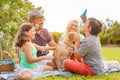 Happy family doing picnic in nature outdoor - Young parents having fun with children and their dog in summer time laughing, Royalty Free Stock Photo