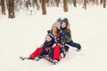 Happy family driving sled on the snow. Mother and her sons having fun in winter park. Winter and christmas holidays Royalty Free Stock Photo