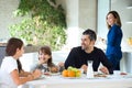 Happy family eating breakfast and having fun in kitchen table at home Royalty Free Stock Photo