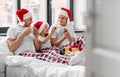 happy family eating coookies in bed on christmas