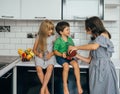 Happy family eating fresh fruit. The concept of healthy eating. funny childs with fruits in the kitchen Royalty Free Stock Photo