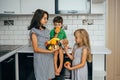Happy family eating fresh fruit. The concept of healthy eating. funny childs with fruits in the kitchen Royalty Free Stock Photo