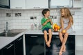 Happy family eating fresh fruit. The concept of healthy eating. funny childs with fruits in the kitchen Royalty Free Stock Photo