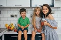 Happy family eating fresh fruit. The concept of healthy eating. funny childs with fruits in the kitchen Royalty Free Stock Photo