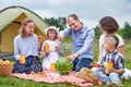 Happy family eating watermelon at picnic in meadow near the tent. Family Enjoying Camping Holiday In Countryside Royalty Free Stock Photo