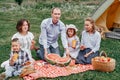 Happy family eating watermelon at picnic in meadow near the tent. Family Enjoying Camping Holiday In Countryside Royalty Free Stock Photo