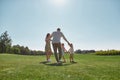 Happy family enjoying leisure activity, spending time together with two little kids, boy and girl in green park on a Royalty Free Stock Photo