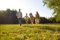 Happy family enjoying leisure time and running together in a beautiful summer park Royalty Free Stock Photo