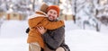 Happy family enjoying snowy weather outdoor, dad with little son hugging during walk in winter park Royalty Free Stock Photo