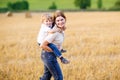 Mother holding kid boy on arms on wheat field in summer Royalty Free Stock Photo