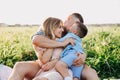 Happy family enjoying together in summer day. Family sitting on grass and embracing. Royalty Free Stock Photo