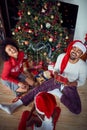 Happy  Family exchanging gifts in front of decorated Christmas tree Royalty Free Stock Photo