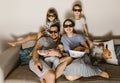 Happy family father with baby on his arms, mother and two daughters in the special glasses watching tv and eating Royalty Free Stock Photo