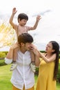 Happy family. Father carry cute son on shoulder, playing at park, mother look at son with love and husband looks at wife with love Royalty Free Stock Photo