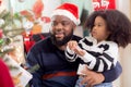 Happy family with father carry daughter decorating ornament on Christmas tree together at home, thanksgiving eve. Royalty Free Stock Photo