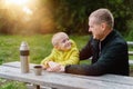 Happy Family: Father And Child Boy Son Playing And Laughing In Autumn Park, Sitting On Wooden Bench And Table. Father Royalty Free Stock Photo