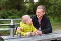 Happy Family: Father And Child Boy Son Playing And Laughing In Autumn Park, Sitting On Wooden Bench And Table. Father Royalty Free Stock Photo