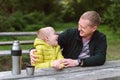 Happy family: father and child boy son playing and laughing in autumn park, sitting on wooden bench and table. Father Royalty Free Stock Photo