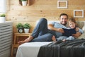 Happy family father and daughter reading book in bed Royalty Free Stock Photo