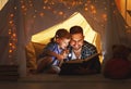 Happy family father and child daughter reading a book in tent Royalty Free Stock Photo