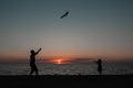 happy family father and child daughter run with kite in the meadow. silhouettes on the background of the sea sunset. Royalty Free Stock Photo