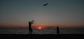 happy family father and child daughter run with kite in the meadow. silhouettes on the background of the sea sunset. Royalty Free Stock Photo