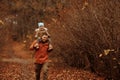 Happy family father and child daughter on a walk in the autumn leaf fall in park Royalty Free Stock Photo