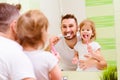 Happy family father and child girl brushing her teeth in bathroom toothbrushes Royalty Free Stock Photo