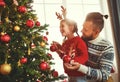 Happy family father and child girl decorated Christmas tree