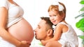 Happy family. father and child kissing belly of mother pregnant Royalty Free Stock Photo