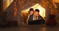 Happy family father and child reading book in tent at home Royalty Free Stock Photo