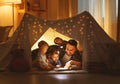 Happy family father and children reading a book in tent at hom Royalty Free Stock Photo