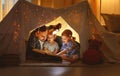 Happy family father and children reading a book in tent at hom Royalty Free Stock Photo