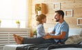 Happy family father and daughter reading book in bed Royalty Free Stock Photo