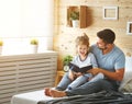 Happy family father and daughter reading book in bed Royalty Free Stock Photo