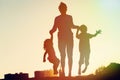 Happy family - father with kids jumping from joy at sunset Royalty Free Stock Photo