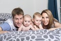 Happy family of father, mother and baby playing in bed Royalty Free Stock Photo