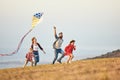 Happy family father,  mother and children launch  kite on nature at sunset Royalty Free Stock Photo