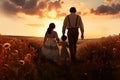 Happy family of father, mother and little daughter walking in the field at sunset, rear view of the Father and his children Royalty Free Stock Photo