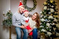 Happy family, father, mother and son, in the morning in living room decorated for Christmas. They open presents and have fun. New Royalty Free Stock Photo