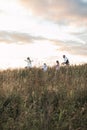 Happy family father, mother and two children daughters running and having fun together on nature summer field at sunset Royalty Free Stock Photo