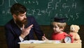 Happy family. Father and son doing homework together. Teacher in formal wear and pupil in mortarboard in classroom Royalty Free Stock Photo