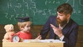 Happy family. Father and son doing homework together. Teacher in formal wear and pupil in mortarboard in classroom Royalty Free Stock Photo