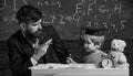 Happy family. Father and son doing homework together. Teacher in formal wear and pupil in mortarboard in classroom Royalty Free Stock Photo