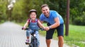 Happy family father teaches child daughter to ride a bike in the Park Royalty Free Stock Photo