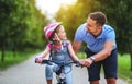 Happy family father teaches child daughter to ride a bike in the Park Royalty Free Stock Photo