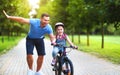 Happy family father teaches child daughter to ride a bike in the Park Royalty Free Stock Photo
