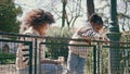 Happy family feeding birds in sunny park. African american girl throwing crumbs Royalty Free Stock Photo